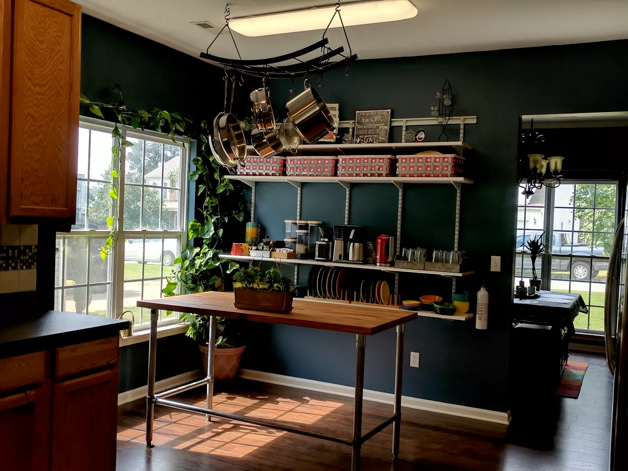 Organized kitchen workspace with hanging pots and open shelving